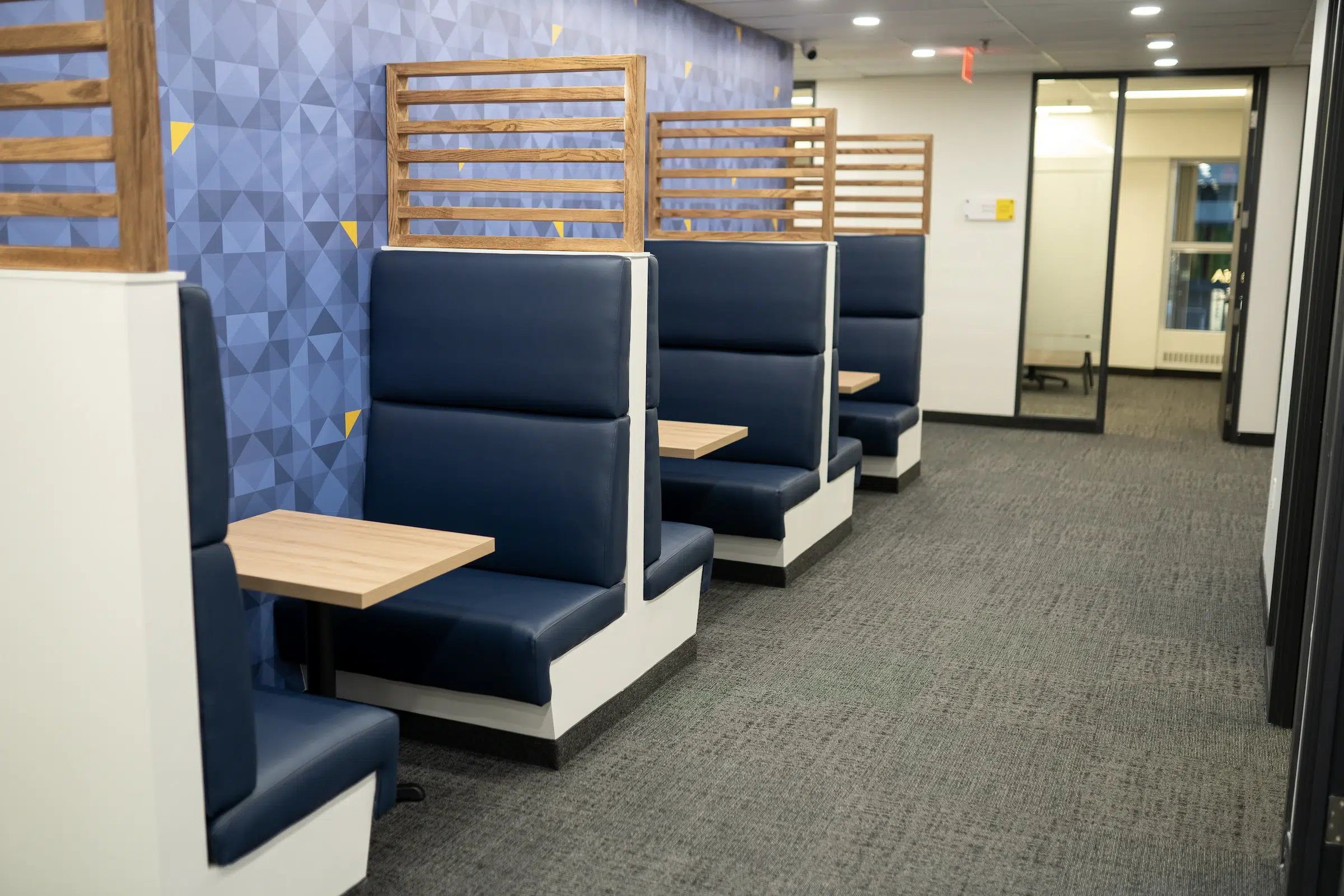 Booth seating with dark blue booths and light wood table.
